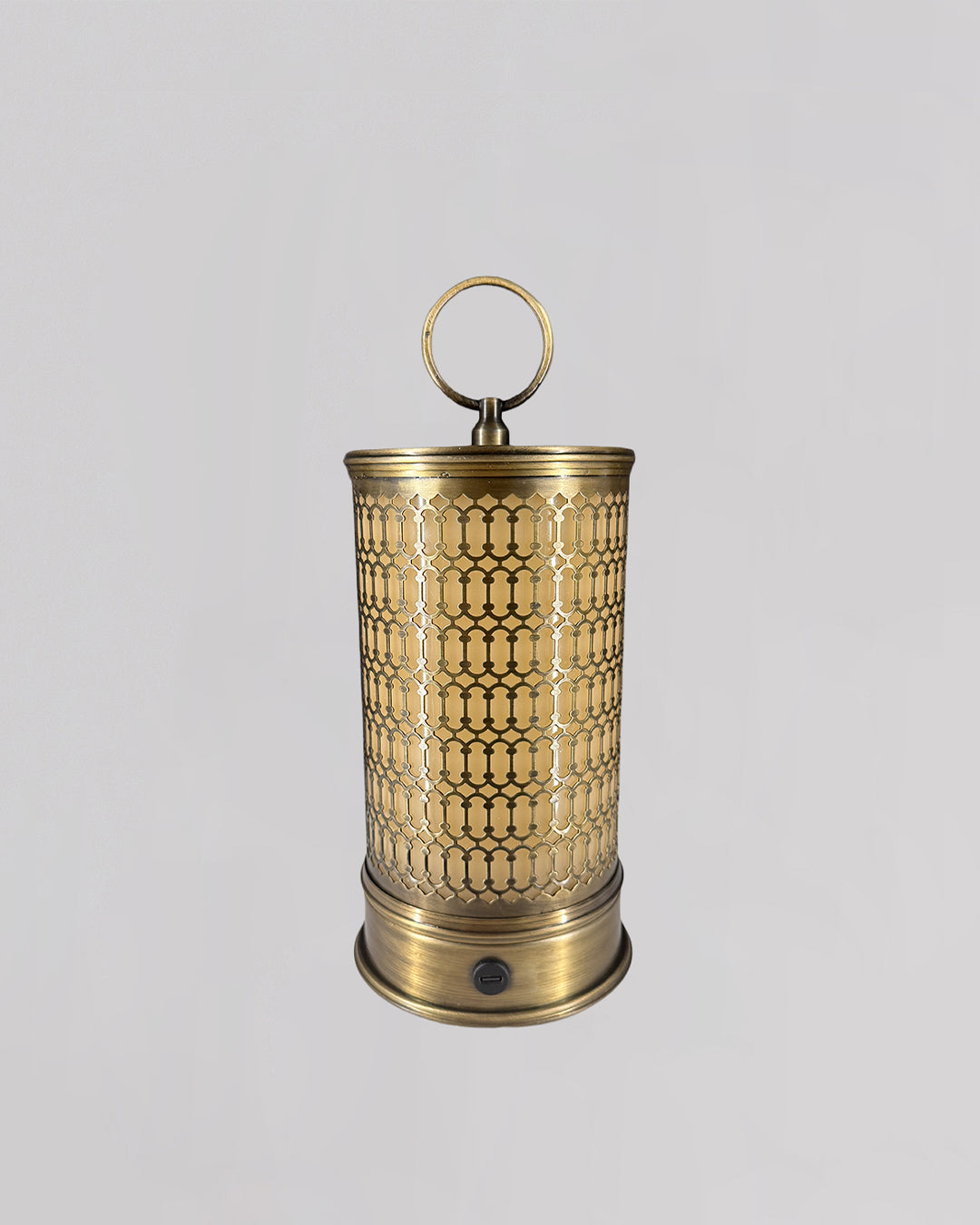 Brass lantern with intricate patterns on a light gray background