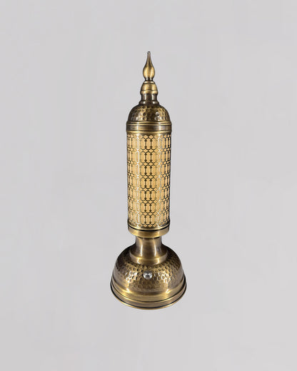 Decorative brass lamp with intricate patterns on a light gray background
