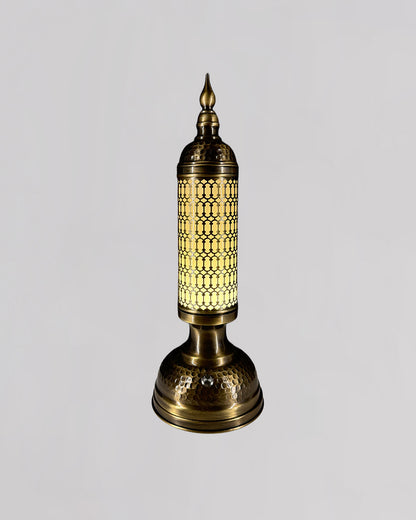 Decorative brass lamp with intricate design on a light gray background