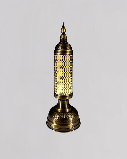 Decorative brass lamp with intricate design on a light gray background