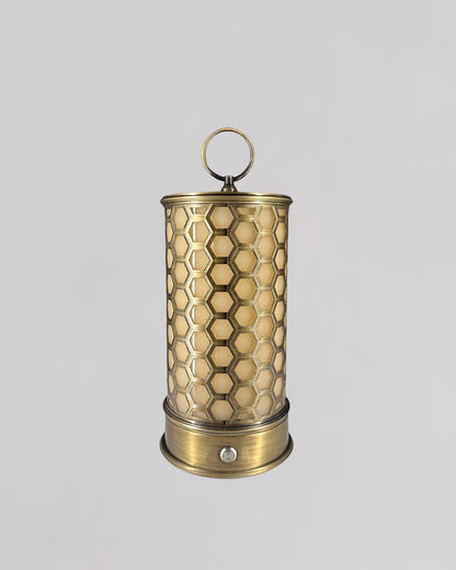 Brass candle holder with honeycomb pattern on a light gray background