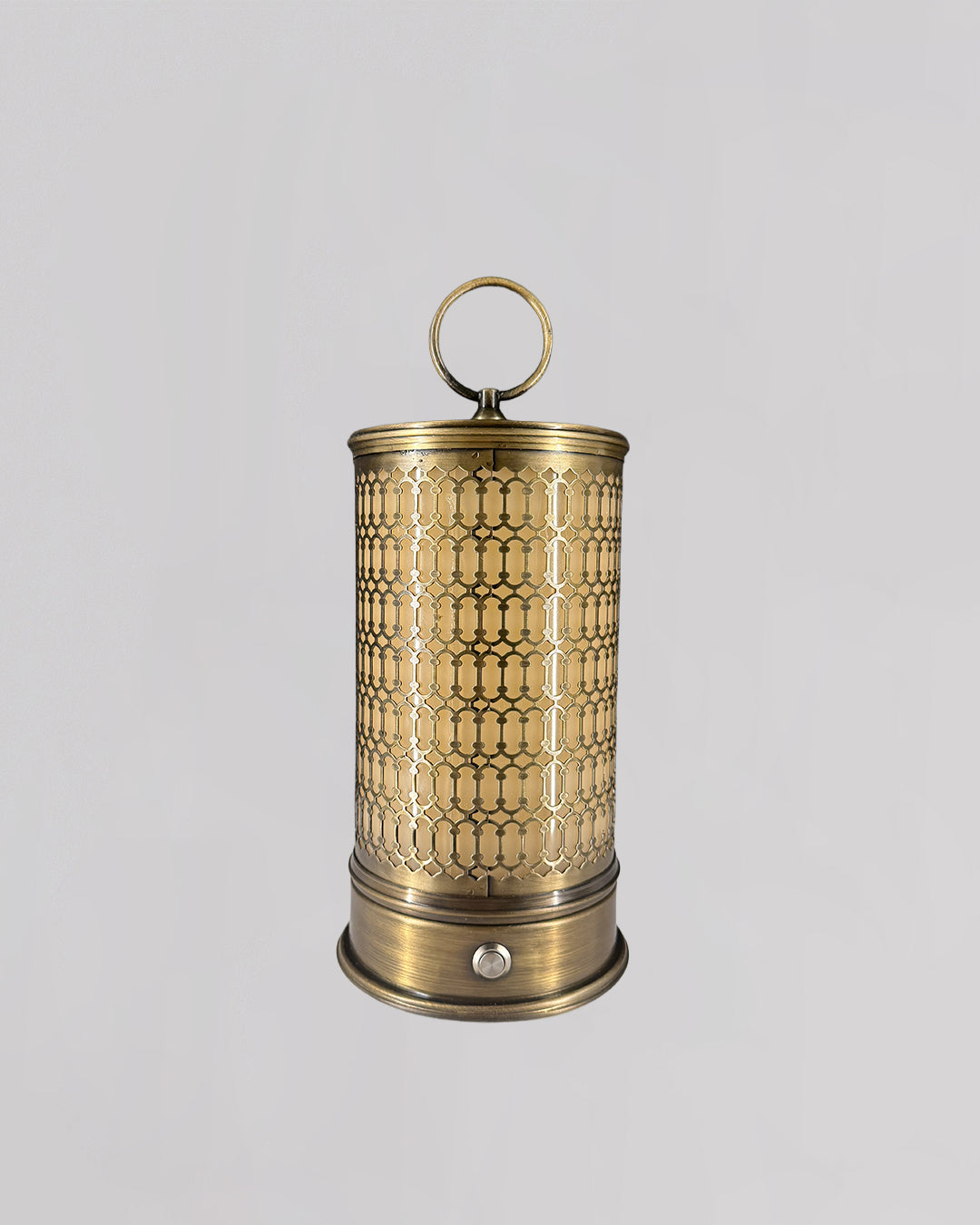 Decorative brass lantern with intricate patterns on a light gray background