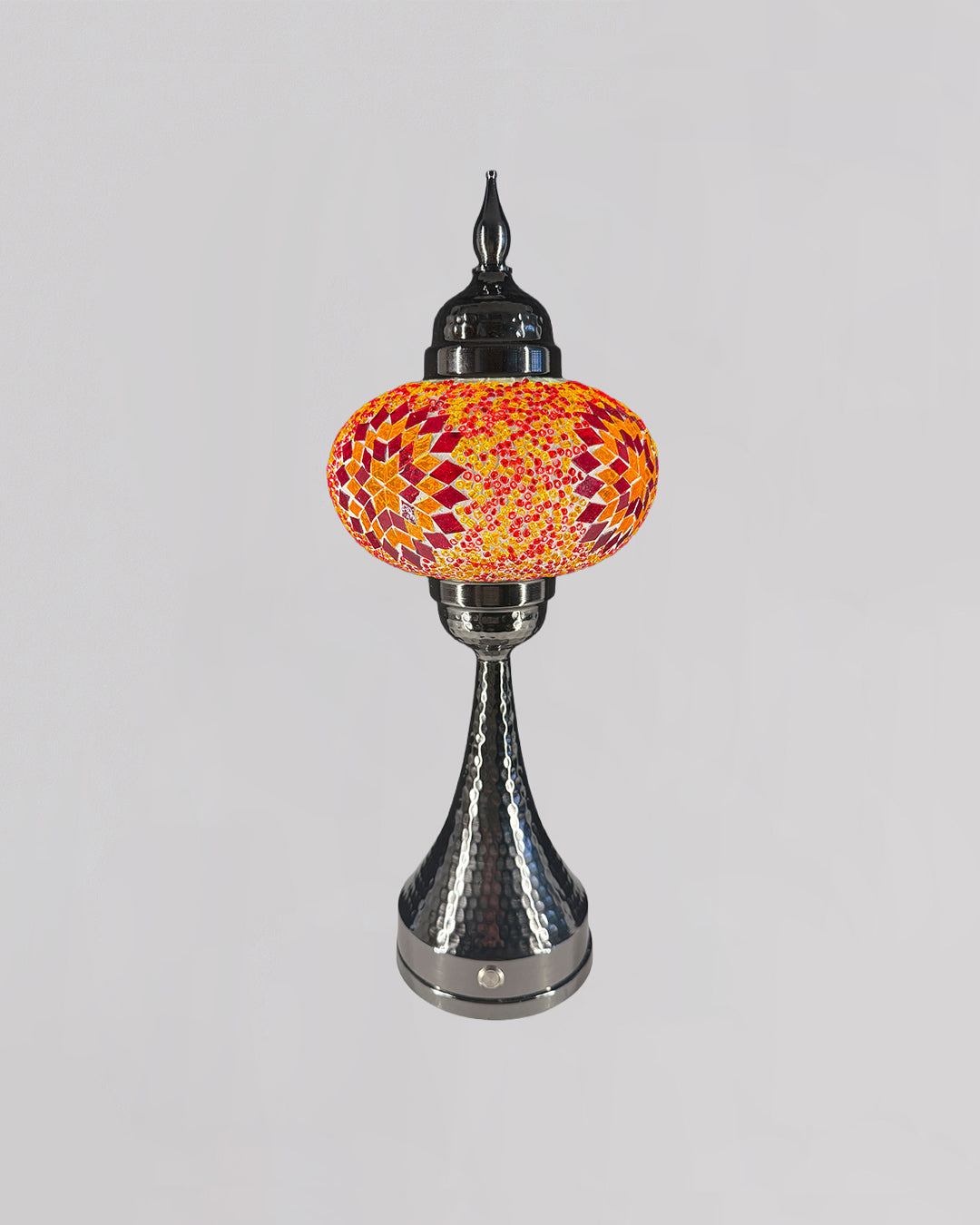 Decorative table lamp with a colorful glass shade on a gray background
