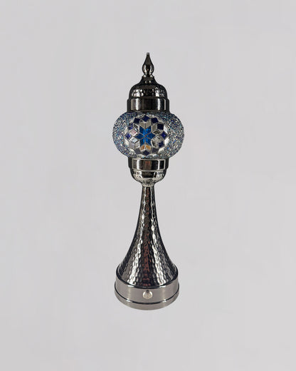 Decorative silver lamp with blue gemstone on a gray background