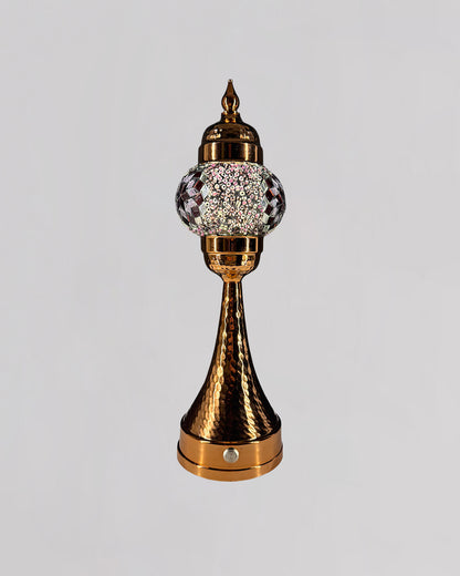 Decorative object with gold and crystal design on a light gray background