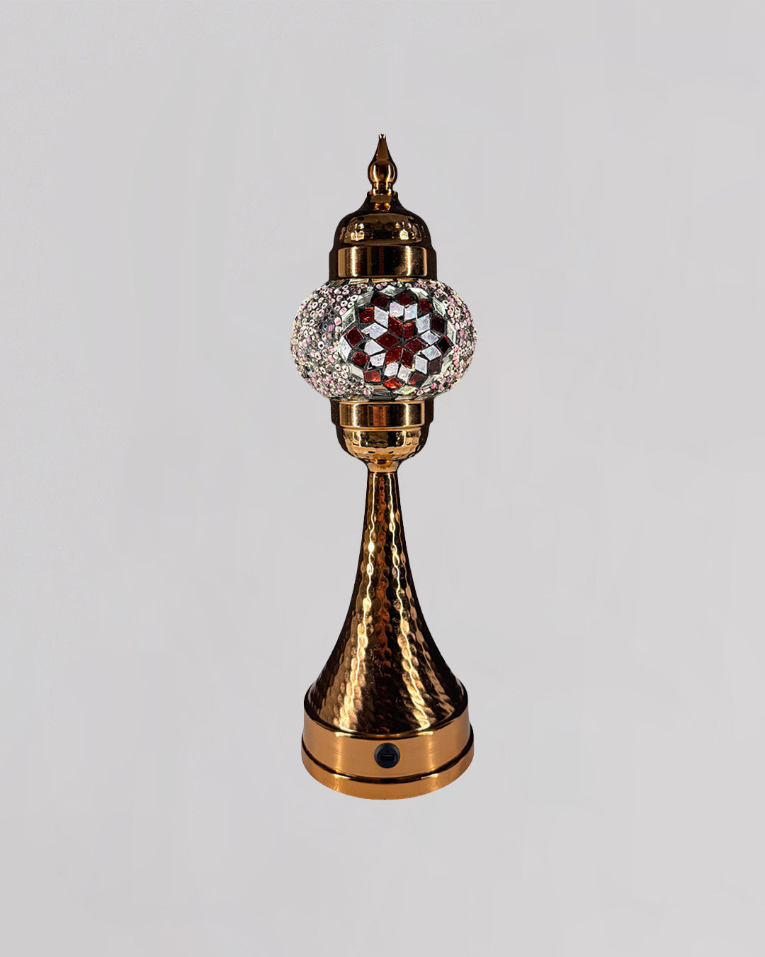 Decorative object with gold and crystal design on a gray background