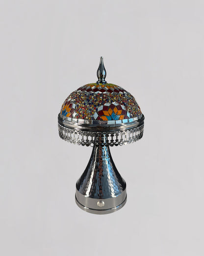 Decorative lamp with mosaic top and metallic base on a light gray background