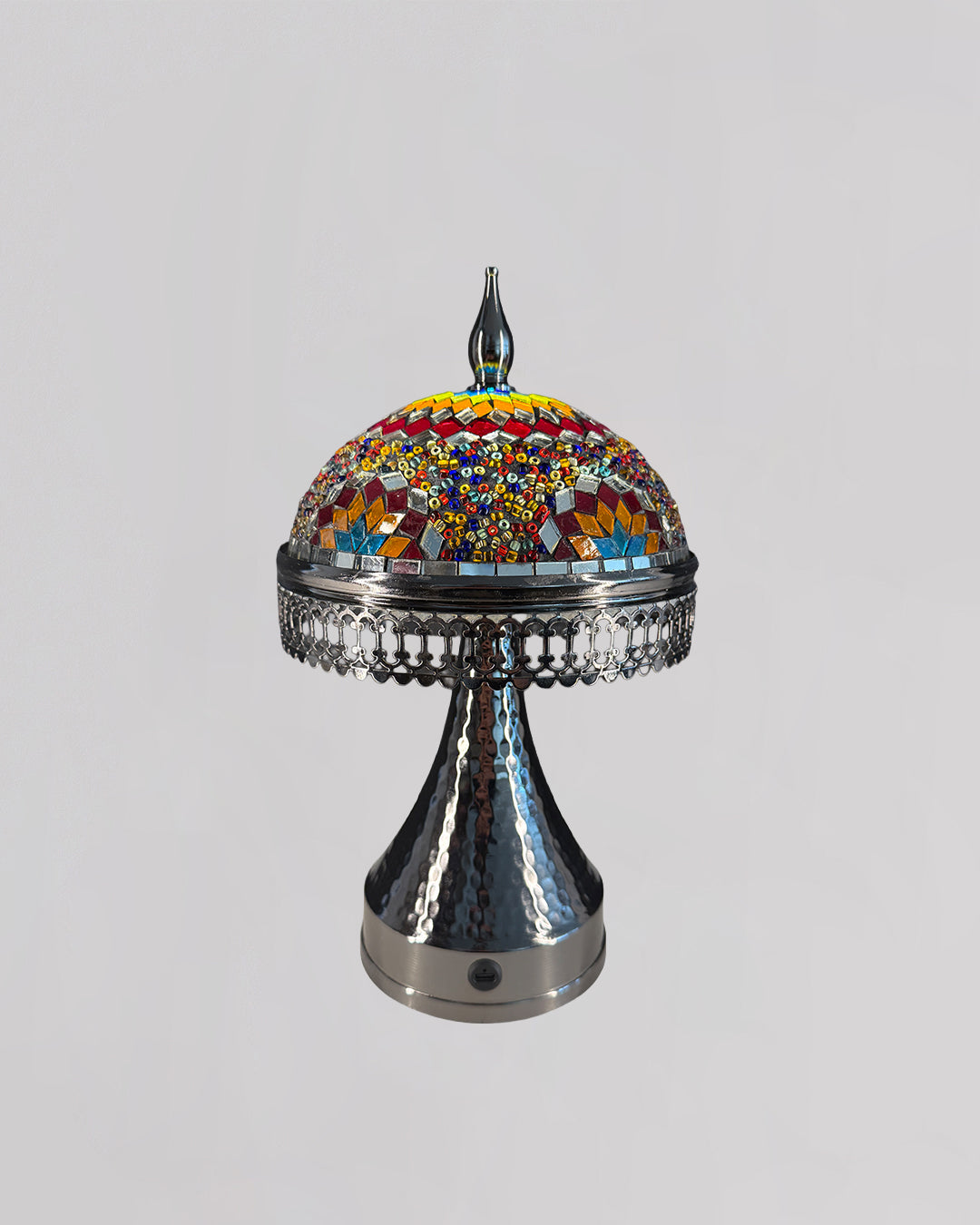 Decorative lamp with colorful mosaic top and metallic base on a light gray background
