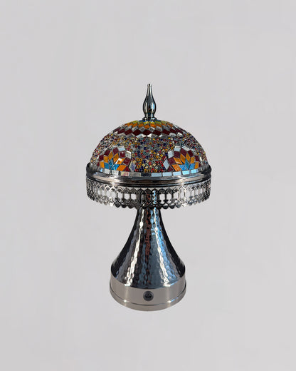 Decorative lamp with mosaic top and metallic base on a light gray background