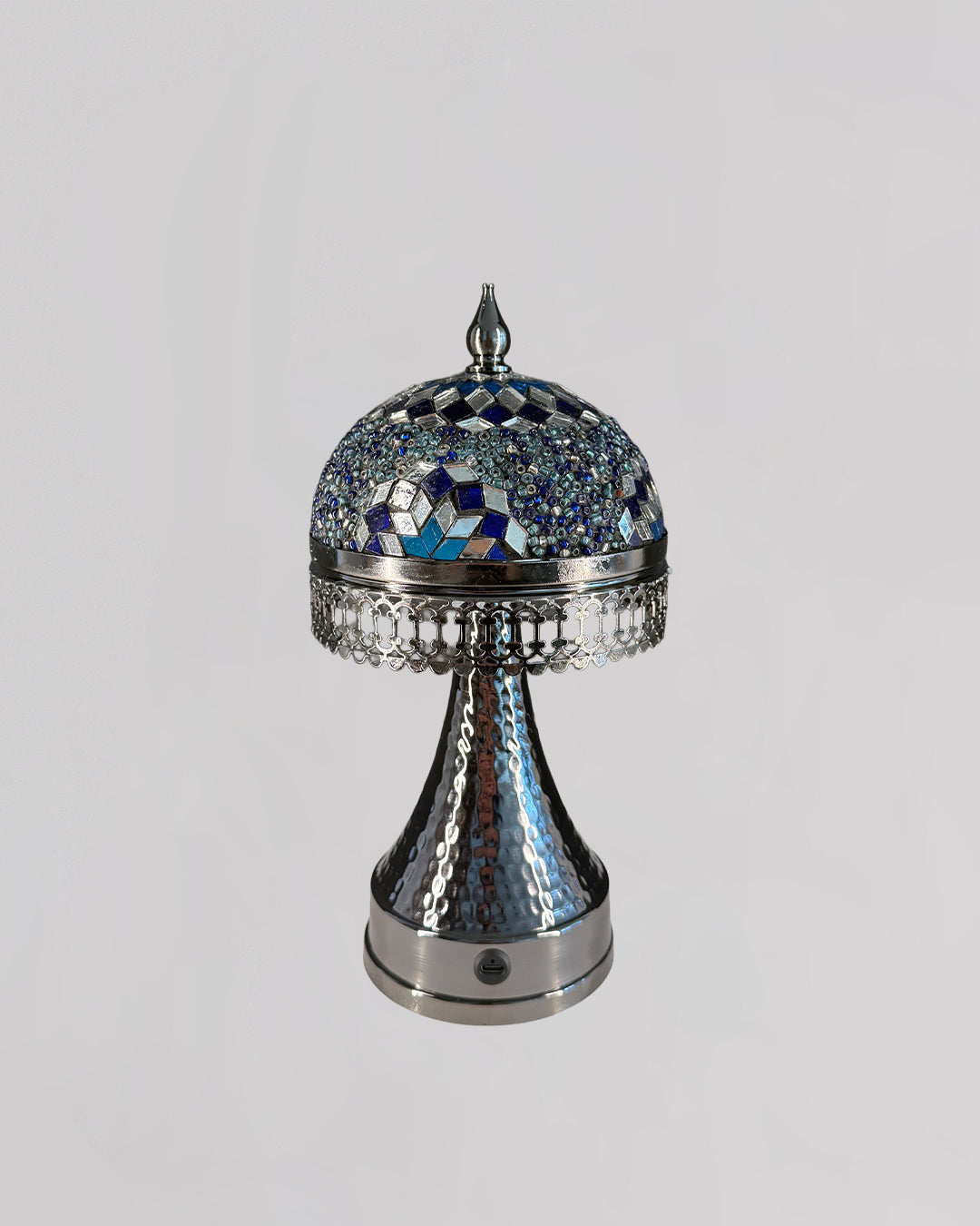 Decorative silver and blue mosaic object on a light gray background