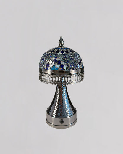Decorative silver and blue mosaic object on a light gray background