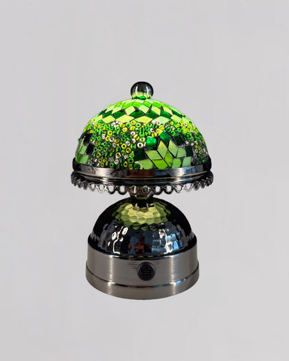 Decorative bell with green checkered top and metallic base on a gray background