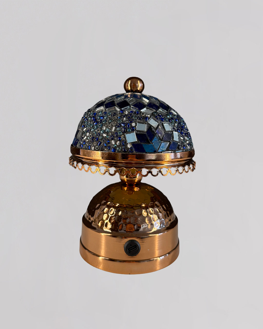 Decorative bell with mosaic top on a light gray background