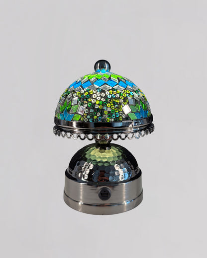 Decorative object with mosaic top and metallic base on a gray background