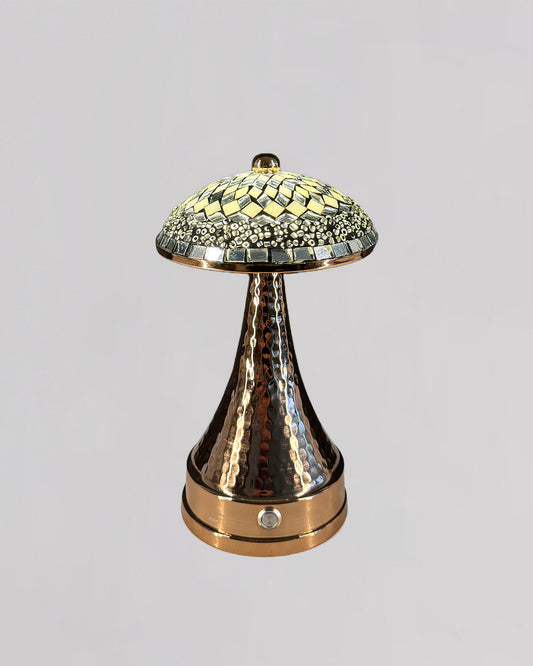 Decorative lamp with mosaic top and hammered bronze base on a light gray background