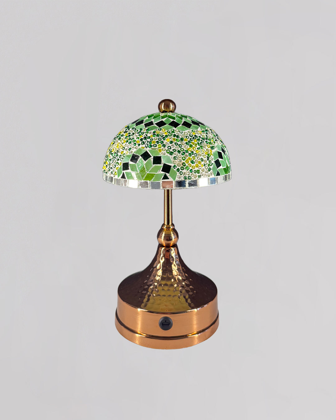 Decorative table lamp with mosaic green shade on a gray background