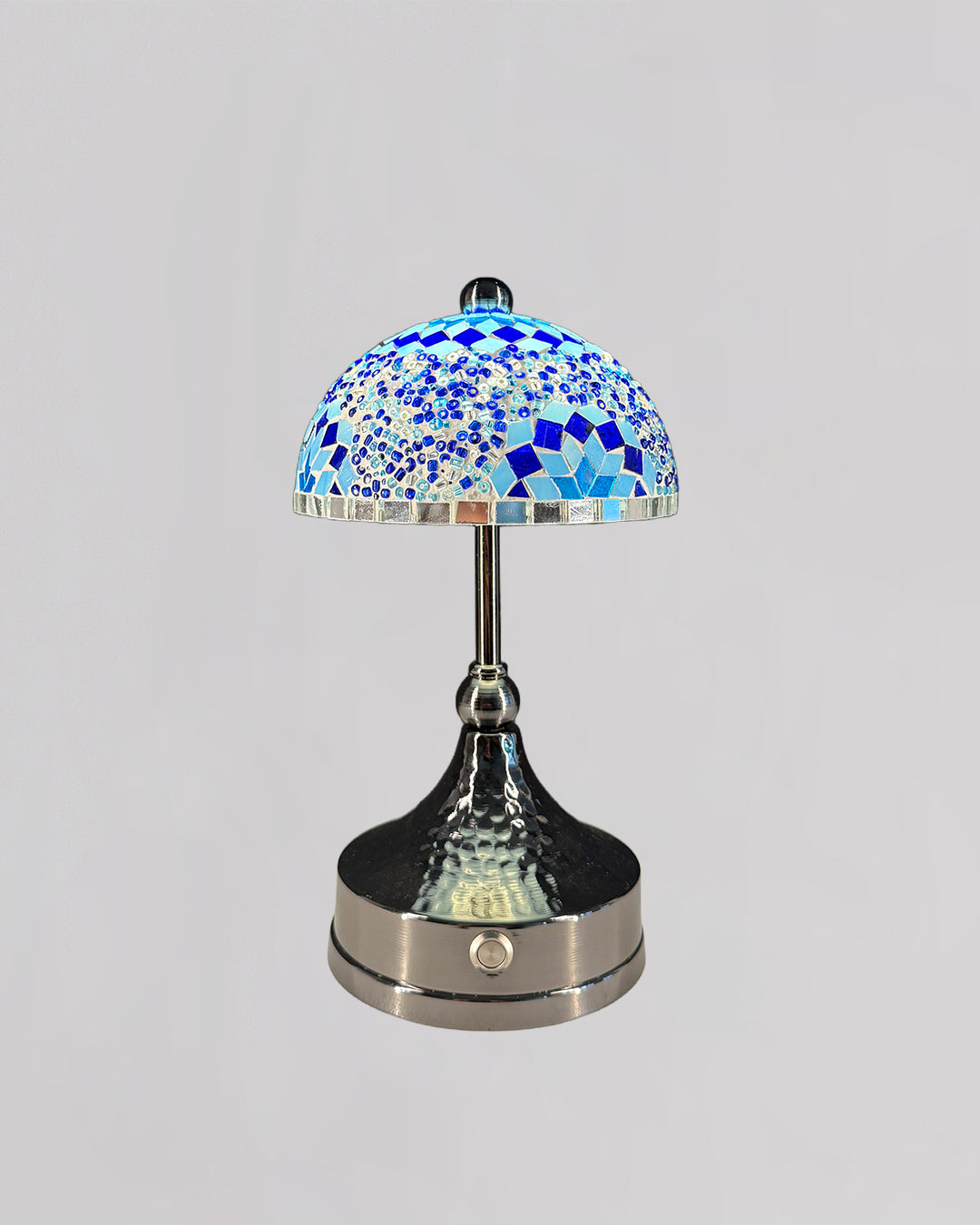 Decorative table lamp with a blue mosaic shade on a gray background
