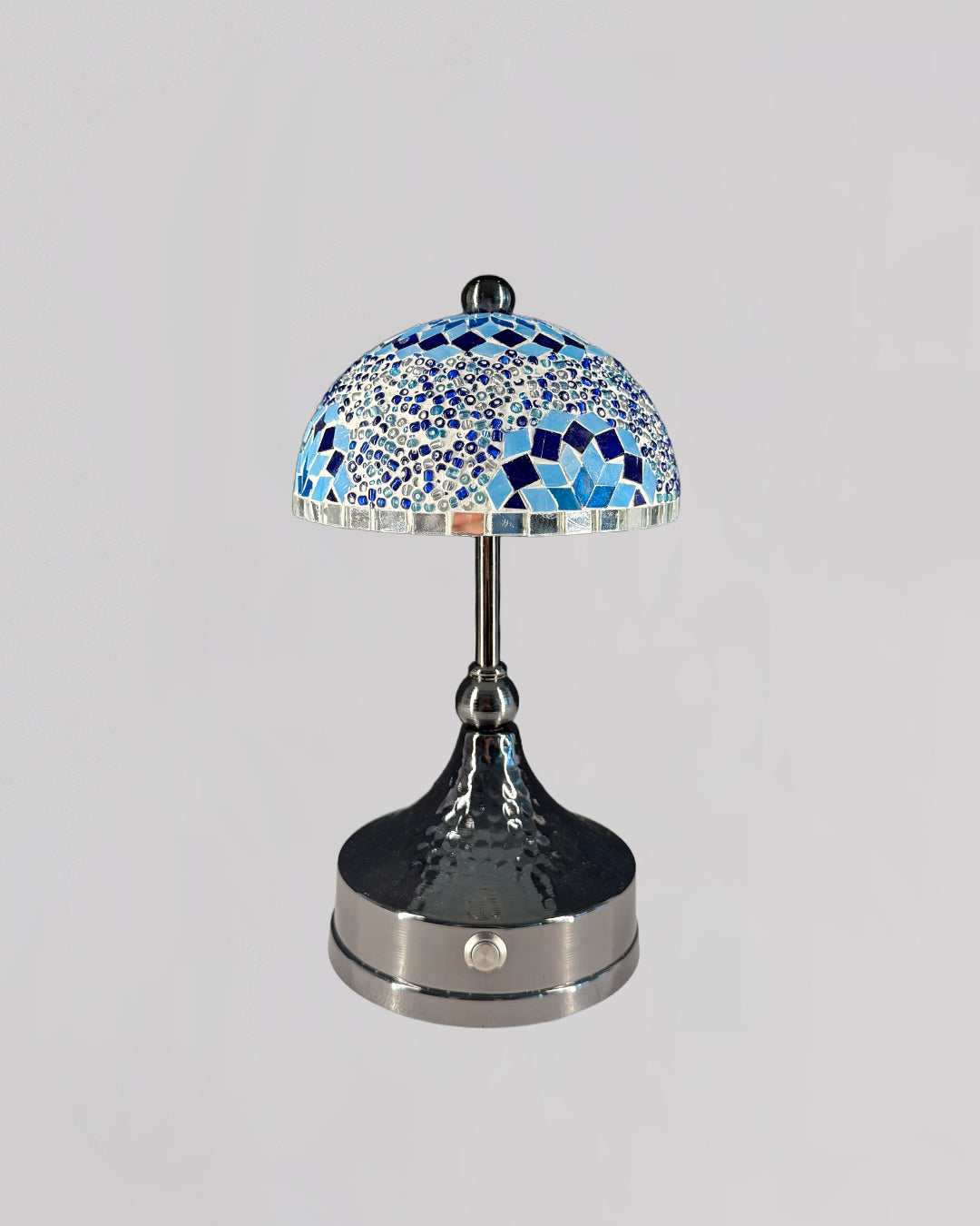 Decorative table lamp with blue mosaic shade on a gray background