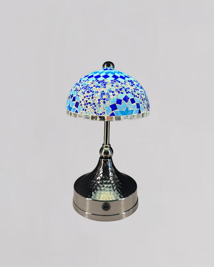 Table lamp with a mosaic blue glass shade on a gray background