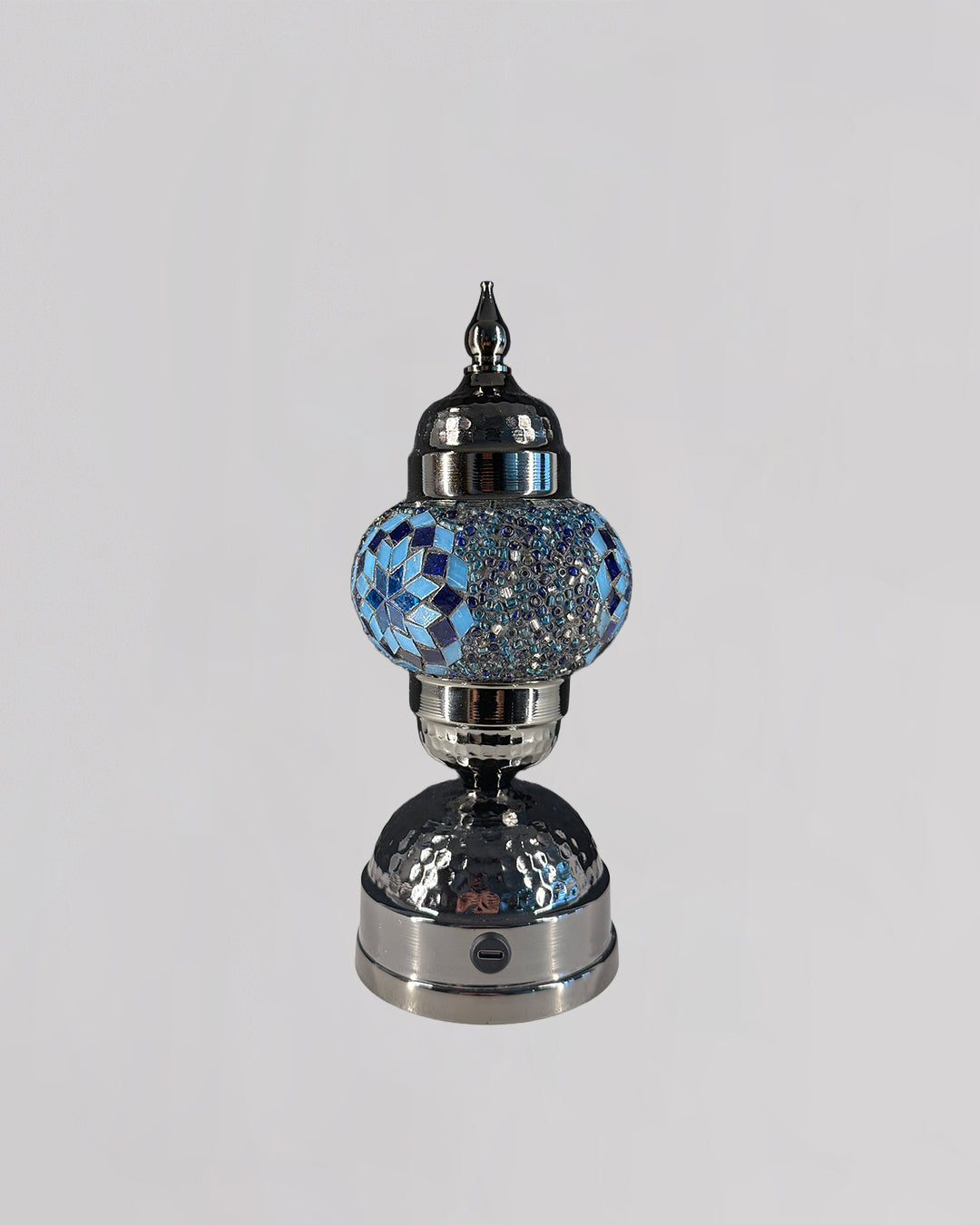 Decorative lamp with blue gemstone-like top on a gray background