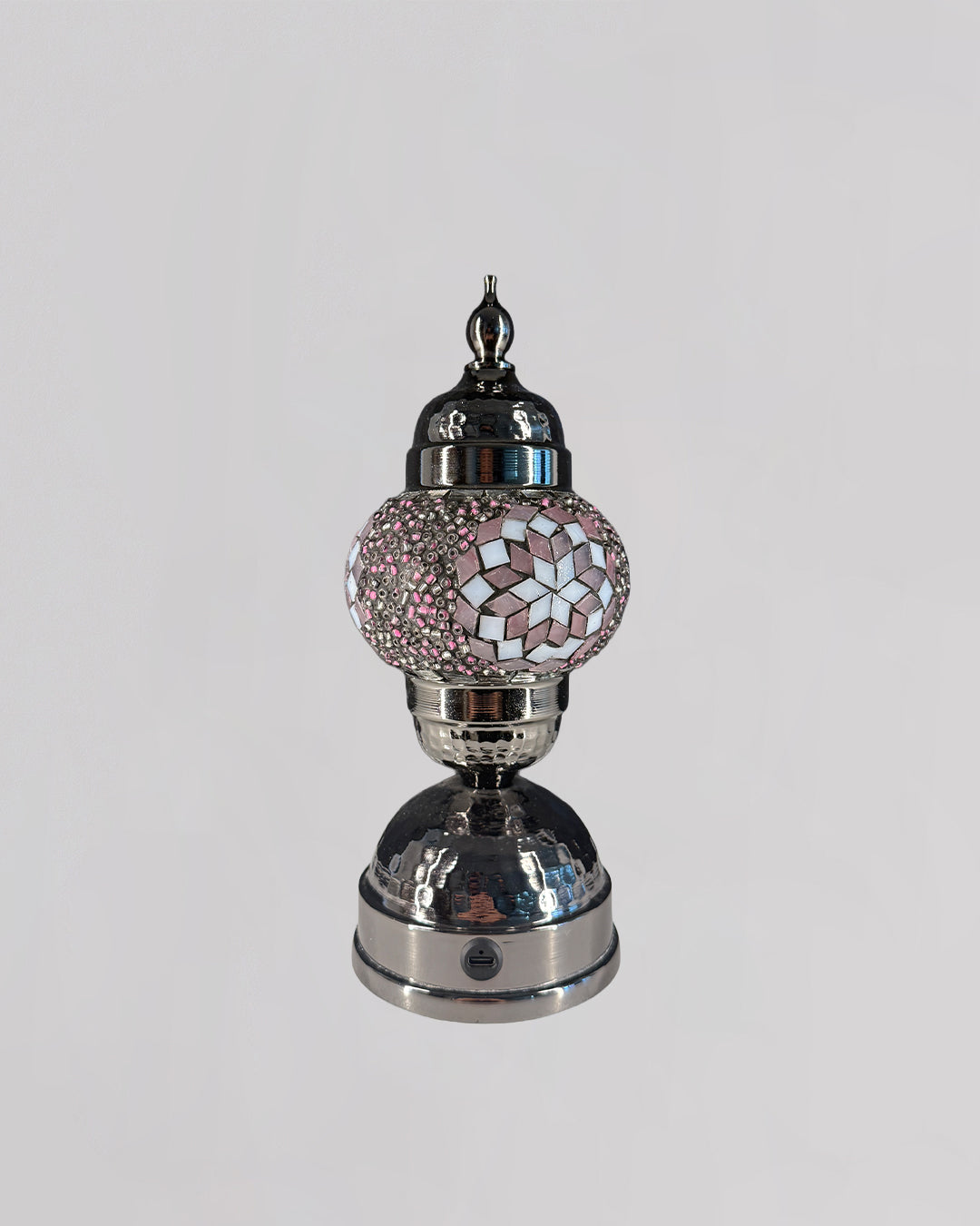 Decorative lamp with a silver base and pink mosaic shade on a white background