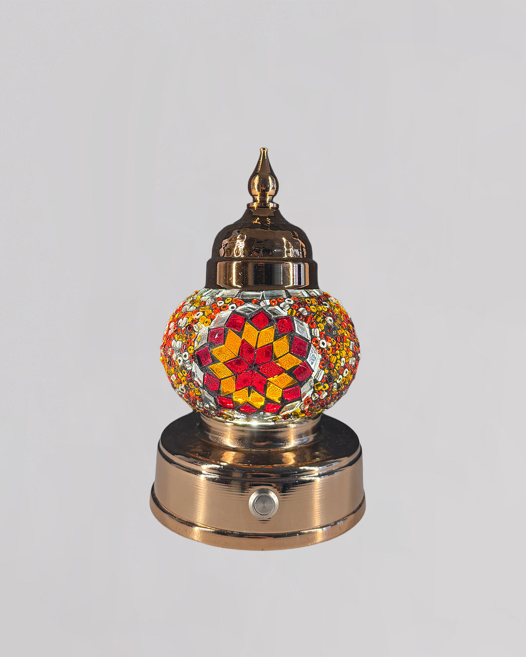 Decorative mosaic lamp with orange and red glass creating rich and warm light.