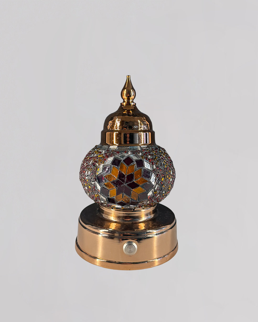 Decorative mosaic lamp with orange and red glass creating rich and warm light.
