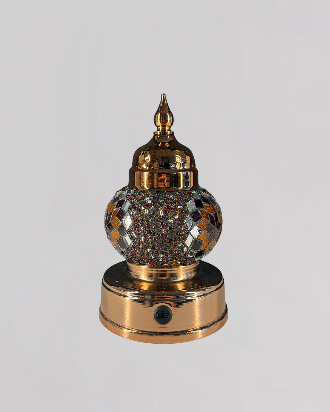 Decorative mosaic lamp with orange and red glass creating rich and warm light.